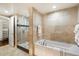 A bathroom with a tub, a glass-door shower, and neutral tile at 6803 E Main St # 2210, Scottsdale, AZ 85251