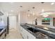 An open kitchen with a granite breakfast bar and stainless appliances looks into the living room at 6803 E Main St # 2210, Scottsdale, AZ 85251