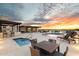 Rooftop entertainment area with swimming pool, lounge chairs, and bar against a colorful sunset at 6803 E Main St # 2210, Scottsdale, AZ 85251
