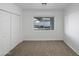 Clean bedroom with neutral carpet, a window offering backyard views, and a closet with double doors at 701 W Wilshire Dr, Phoenix, AZ 85007