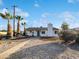 Charming single-story home with a blue door and white exterior, complemented by desert landscaping and palm trees at 701 W Wilshire Dr, Phoenix, AZ 85007