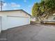 A detached one-car garage features a fresh coat of paint and ample driveway space in front of a home with mature landscaping at 701 W Wilshire Dr, Phoenix, AZ 85007