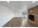 Bright living room featuring a stone fireplace, wood floors, and a window with natural light at 701 W Wilshire Dr, Phoenix, AZ 85007