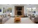 Bright living room featuring a stone fireplace, neutral furniture, and bay windows with a view at 701 W Wilshire Dr, Phoenix, AZ 85007