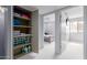 Hallway features bedroom entrance and open storage shelves with linen and supplies at 7720 E Heatherbrae Ave # 13, Scottsdale, AZ 85251
