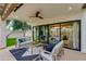 Inviting covered patio with modern ceiling fan, stylish furniture, and seamless indoor-outdoor flow through sliding glass doors at 7721 N Via De La Montana --, Scottsdale, AZ 85258