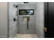 Walk-in shower with gray tiling, a stone floor, and a black shower head at 7721 N Via De La Montana --, Scottsdale, AZ 85258