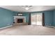 Comfortable living room featuring a cozy fireplace, neutral carpet, and access to the backyard at 819 E 6Th Ave, Mesa, AZ 85204