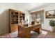 Home office with rustic wooden desk, bookshelves, and neutral decor at 9990 N Scottsdale Rd # 2049, Paradise Valley, AZ 85253