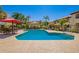 Community pool featuring lounge seating, lush landscaping and red umbrellas at 9990 N Scottsdale Rd # 2049, Paradise Valley, AZ 85253