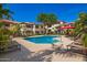 Community pool surrounded by sun loungers and red umbrellas at 9990 N Scottsdale Rd # 2049, Paradise Valley, AZ 85253