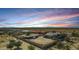 This aerial view showcases the home in the desert with a sunset sky at 10203 N Burris Rd, Casa Grande, AZ 85122