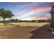 Large gravel backyard with mature tree near the back and beautiful sunset lighting at 10203 N Burris Rd, Casa Grande, AZ 85122