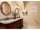 Double vanity bathroom with granite counters, decorative mirrors, and stylish fixtures at 10203 N Burris Rd, Casa Grande, AZ 85122