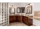 Bathroom with dual vanity sinks, wood-framed mirrors, glass block window, and beige cabinets at 10203 N Burris Rd, Casa Grande, AZ 85122