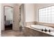 Luxurious bathroom with a soaking tub, glass block window, and elegant tile work at 10203 N Burris Rd, Casa Grande, AZ 85122