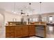 Spacious kitchen featuring custom wood cabinets, counter seating, a stainless steel dishwasher, and stainless steel appliances at 10203 N Burris Rd, Casa Grande, AZ 85122