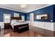 Main bedroom with a navy accent wall, hardwood floors, and a luxury design, and a large bed at 10203 N Burris Rd, Casa Grande, AZ 85122