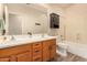 Bathroom showcasing a double sink vanity, wood-style flooring, and a tub/shower combination at 10339 E Juanita Ave, Mesa, AZ 85209