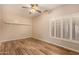 Inviting bedroom featuring a ceiling fan, plantation shutters, and wood-style flooring at 10339 E Juanita Ave, Mesa, AZ 85209