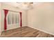 Charming bedroom offering a ceiling fan, wood-style floors, plantation shutters, and neutral colors at 10339 E Juanita Ave, Mesa, AZ 85209