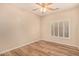 Inviting bedroom featuring a ceiling fan, plantation shutters, and wood-style flooring at 10339 E Juanita Ave, Mesa, AZ 85209