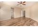 Well lit bedroom with tile flooring, a ceiling fan, and three interior doors at 10339 E Juanita Ave, Mesa, AZ 85209