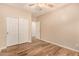 Bright bedroom showcasing a closet, ceiling fan, and neutral walls with wood-style flooring at 10339 E Juanita Ave, Mesa, AZ 85209