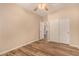 Bright bedroom showcasing a closet, ceiling fan, and neutral walls with wood-style flooring at 10339 E Juanita Ave, Mesa, AZ 85209