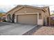 Two car garage with beige facade, and neutral trim complemented by desert landscaping at 10339 E Juanita Ave, Mesa, AZ 85209