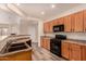 Well-lit kitchen with black appliances, and wood cabinets, perfect for cooking and entertaining at 10339 E Juanita Ave, Mesa, AZ 85209