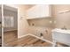 Bright laundry room boasts wood-look tile flooring, sink, and lots of cabinet storage at 10339 E Juanita Ave, Mesa, AZ 85209