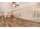 Large living room featuring wood-look floors, plantation shutters, and an open layout at 10339 E Juanita Ave, Mesa, AZ 85209