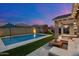 Inviting backyard featuring a sparkling pool, outdoor seating, and a play structure against a vibrant twilight sky at 10702 E Sheffield Dr, Mesa, AZ 85212