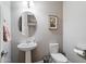 Charming half-bath with a pedestal sink, stylish decor, and neutral color scheme at 10702 E Sheffield Dr, Mesa, AZ 85212