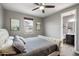 Cozy bedroom with a tufted headboard, ceiling fan, and ensuite bathroom at 10702 E Sheffield Dr, Mesa, AZ 85212