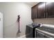 Laundry room with modern gray washer and dryer, cabinets, and a Dyson vacuum at 10702 E Sheffield Dr, Mesa, AZ 85212