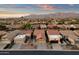 Stunning aerial view of desert homes with red tile roofs nestled against a mountain backdrop at sunset at 10758 E Peralta Canyon Dr, Gold Canyon, AZ 85118