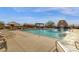 Inviting community pool featuring lounge chairs, shaded seating areas, and a decorative desert landscape at 10758 E Peralta Canyon Dr, Gold Canyon, AZ 85118