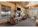 Cozy living room features a stone fireplace, comfortable seating, and ample natural light at 10758 E Peralta Canyon Dr, Gold Canyon, AZ 85118