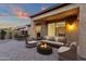 This private outdoor patio features a cozy fire pit and dining area with a picturesque sunset sky at 10758 E Peralta Canyon Dr, Gold Canyon, AZ 85118