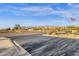 Wide street view of a community entrance with desert landscaping, mountain views, and an American flag at 10758 E Peralta Canyon Dr, Gold Canyon, AZ 85118