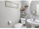 Powder room featuring a white toilet and sink, wall decor, and modern fixtures at 10840 W Saddlehorn Rd, Peoria, AZ 85383