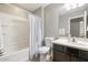 Bathroom featuring a tub-shower combo, dark vanity, tile floors and neutral gray walls at 10840 W Saddlehorn Rd, Peoria, AZ 85383