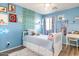 Charming blue bedroom featuring a daybed with storage and décor, hardwood floors and whimsical artwork at 10840 W Saddlehorn Rd, Peoria, AZ 85383