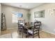 Neutral dining room with dark wood table, window, and decorative mirror at 10840 W Saddlehorn Rd, Peoria, AZ 85383