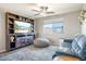 Comfortable living room featuring a media center, ceiling fan, and contemporary decor, filled with natural light at 10840 W Saddlehorn Rd, Peoria, AZ 85383