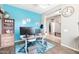 Inviting office space with blue accent wall and a bright rug, featuring hardwood floors at 10840 W Saddlehorn Rd, Peoria, AZ 85383