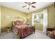 Comfortable bedroom with vibrant quilt, ceiling fan, and a sunlit window at 11056 E Nopal Ave, Mesa, AZ 85209