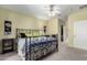 A cozy bedroom showcasing a wrought iron bed frame and neutral-toned walls at 11056 E Nopal Ave, Mesa, AZ 85209